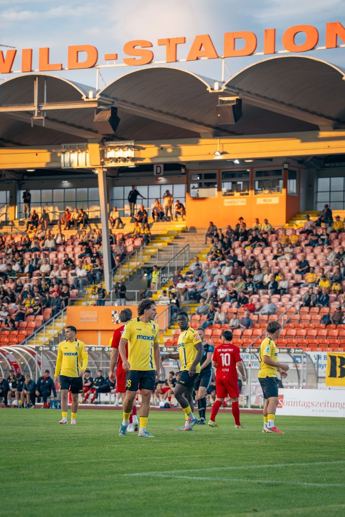 Spieler von der SpVgg Bayreuth und des TSV Aubstadt vor der Haupttribüne des Hans-Walter-Wild-Stadions